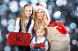 Photo: Hübsche Santa Frau mit Kinder und Geschenke Sack Hübsche Santa Frau mit Kinder und Geschenke Sack