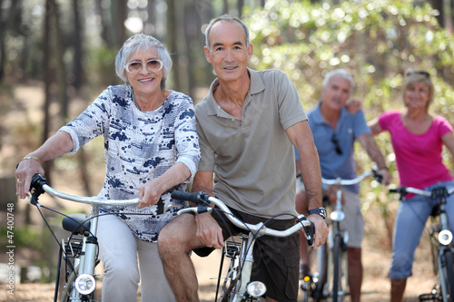 Photo: Mature couples on a double date biking. Mature couples on a double date biking.