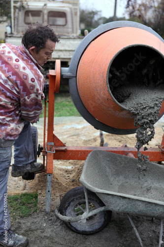 Photo: Builder using a cement mixer Builder using a cement mixer