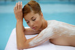Foto: Woman laid on massage table with cream on her back Woman laid on massage table with cream on her back