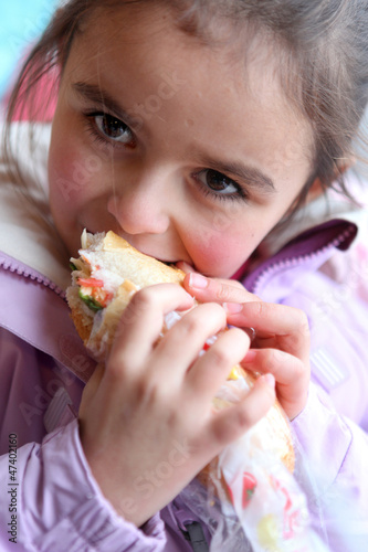 Photo: Little girl eating sandwich Little girl eating sandwich