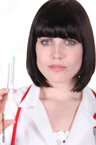 Photo: Female doctor holding syringe Female doctor holding syringe