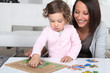 Mother and daughter completing jigsaw