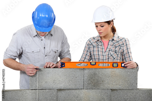 Photo: Bricklayers with a spirit level and plumb line Bricklayers with a spirit level and plumb line