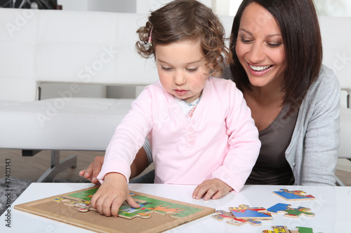 Photo: Mother and daughter completing jigsaw Mother and daughter completing jigsaw