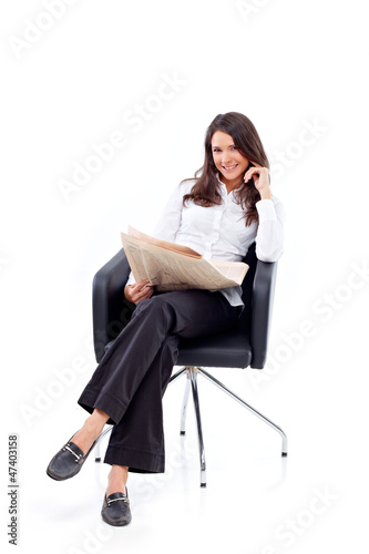 Photo: Casual 20s woman reading stock rates in newspaper 6 Casual 20s woman reading stock rates in newspaper 6