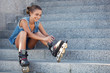 girl sitting on the stairs and puts on skates