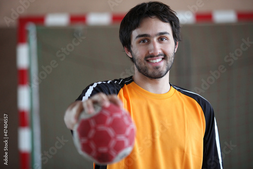 Photo: portrait of young handball player holding out ball portrait of young handball player holding out ball
