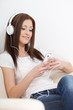 Foto: woman sitting on sofa and looking at player woman sitting on sofa and looking at player