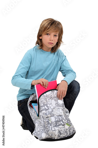 Photo: Boy packing school bag Boy packing school bag