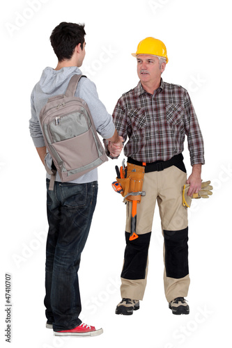 Photo: senior craftsman and young apprentice shaking hands senior craftsman and young apprentice shaking hands