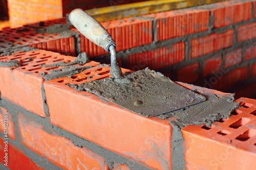 Photo: Puddle on brick with cement, bricklayer Puddle on brick with cement, bricklayer