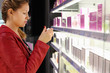 woman with braid chooses perfume in small perfume shop.