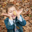 Enfant jouant avec des feuilles mortes