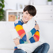 frau mit kissen auf dem sofa