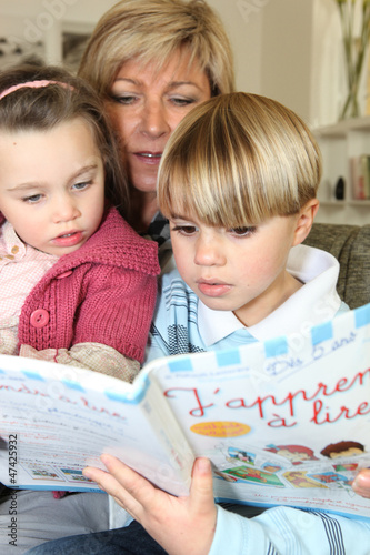Photo: Mother read book with her two children Mother read book with her two children