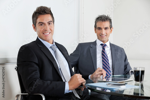 Photo: Businessmen Using Digital Tablet In Office Businessmen Using Digital Tablet In Office
