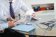 Foto: Businessman With Colleague Discussing Paperwork Businessman With Colleague Discussing Paperwork