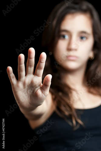 Photo: Hispanic girl with a hand extended signaling to stop Hispanic girl with a hand extended signaling to stop