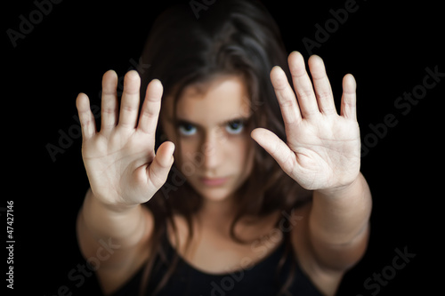 Photo: Hispanic girl signaling to stop isolated on black Hispanic girl signaling to stop isolated on black