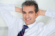 Mid Adult Businessman Relaxing With Hands Behind Head