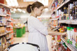 Photo: Mid Adult Woman Using Digital Tablet At Supermarket Mid Adult Woman Using Digital Tablet At Supermarket