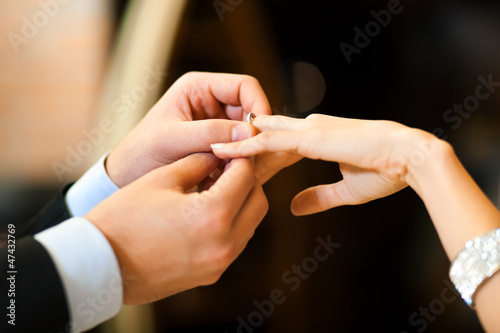 Photo: Man gently sticks a diamond ring on the finger of his fiance Man gently sticks a diamond ring on the finger of his fiance