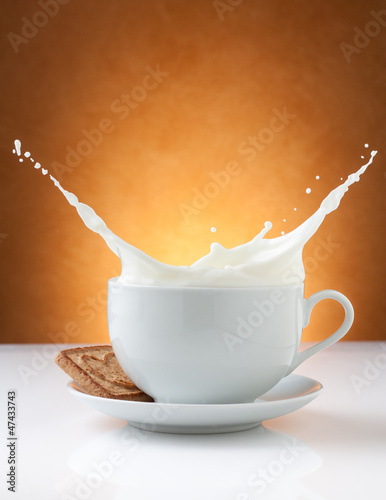 Photo: cup of milk splash with biscuit cup of milk splash with biscuit