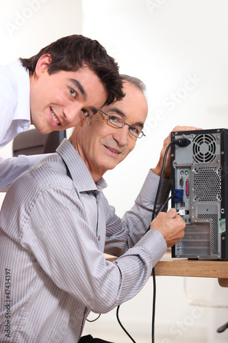 Photo: grandson and grandfather connecting a computer grandson and grandfather connecting a computer