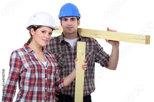 Photo: male and female carpenters carrying timber male and female carpenters carrying timber