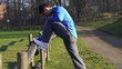 Man stretching, woman jogging in park, slow motion