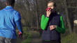 Woman eat apple after workout, man jogging, super slow motion