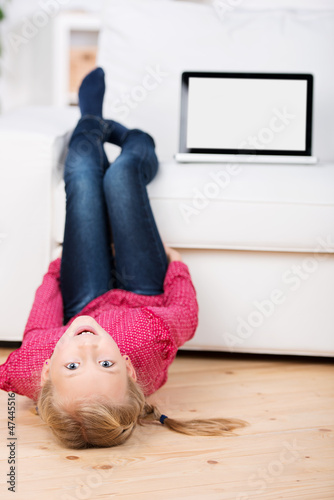 Photo: mädchen mit laptop liegt auf dem fußboden mädchen mit laptop liegt auf dem fußboden