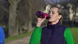 Woman drinking water, man jogging, super slow motion