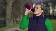 Woman drinking water after jogging