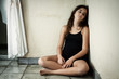 Sad and lonely hispanic girl sitting in a corner