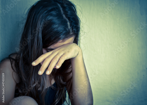 Photo: Lonely girl crying with a hand covering her face Lonely girl crying with a hand covering her face
