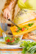 Woman s hands cutting fresh onions, dill, parsley on kitchen