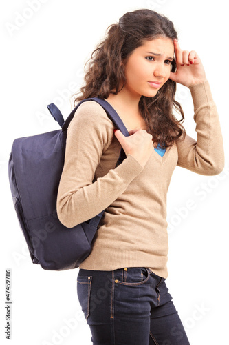 Photo: A sad female teenager with a school bag on her back posing A sad female teenager with a school bag on her back posing