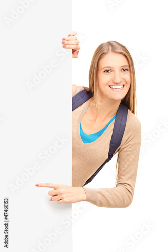 Photo: Smiling female student pointing on a blank panel Smiling female student pointing on a blank panel