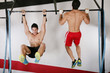 athletic group executing exercise tightening on horizontal bar.