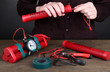 Human makes timebomb on wooden table on black background