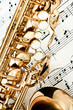Foto: Saxophone keys closeup with score notes in background Saxophone keys closeup with score notes in background