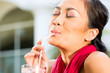 Asian woman in restaurant drinking
