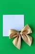 Foto: white blank with a gold bow on a green background white blank with a gold bow on a green background