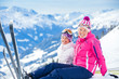 Young skier sitting on the hill