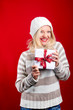 pretty blonde girl holding a christmas present is smiling