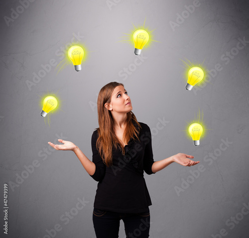 Photo: young lady standing and juggling with light bulbs young lady standing and juggling with light bulbs