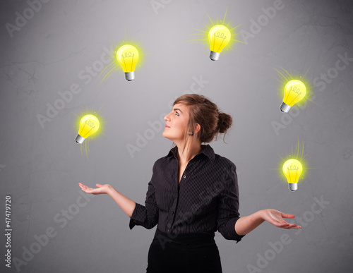 Photo: young lady standing and juggling with light bulbs young lady standing and juggling with light bulbs