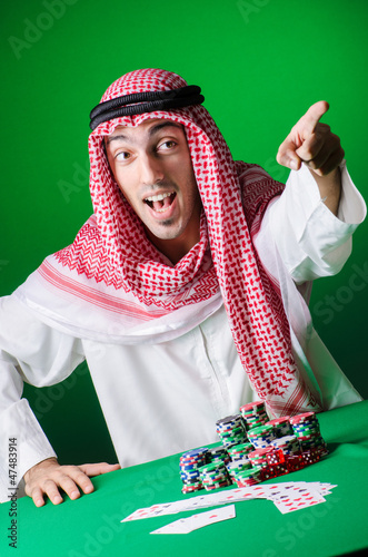 Photo: Arab playing in casino - gambling concept with man Arab playing in casino - gambling concept with man